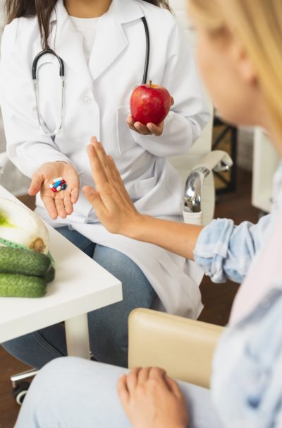 close-up-doctor-comparing-fruits-pills